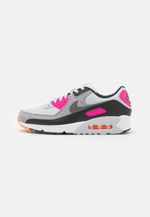 Nike Air Max sneaker in white, gray, black, and pink with visible air cushion in the sole and lace-up closure on a white background.