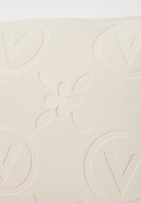 Textured white leather pouch featuring embossed floral and circular “V” patterns, with a smooth finish and subtle detailing.