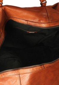 Sac fourre-tout en cuir marron avec un intérieur en tissu noir spacieux, doté d'une fermeture éclair et sans poches extérieures ni décorations.