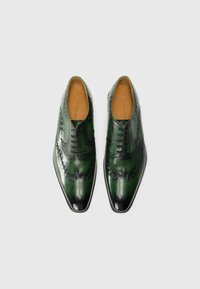 Green leather shoes with a glossy finish, pointed toe, textured paneling, and decorative stitching along the edges.