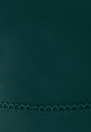 Tmavě zelená látka s hladkým povrchem, zdobená dekorativním vlnitým okrajem podél spodního okraje.