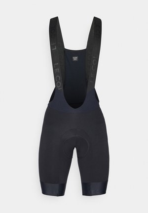 Black cycling bib shorts made of stretchy fabric with padded chamois. Features adjustable straps and a smooth finish at the hem.