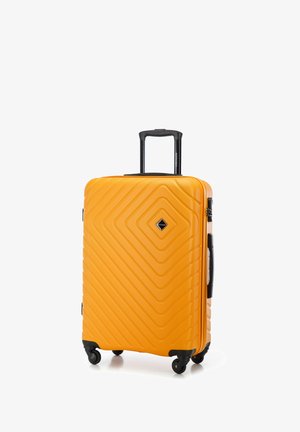 Żółta walizka twarda z teksturą w zygzaki, cztery czarne kółka, teleskopowy uchwyt i logo w kształcie diamentu.