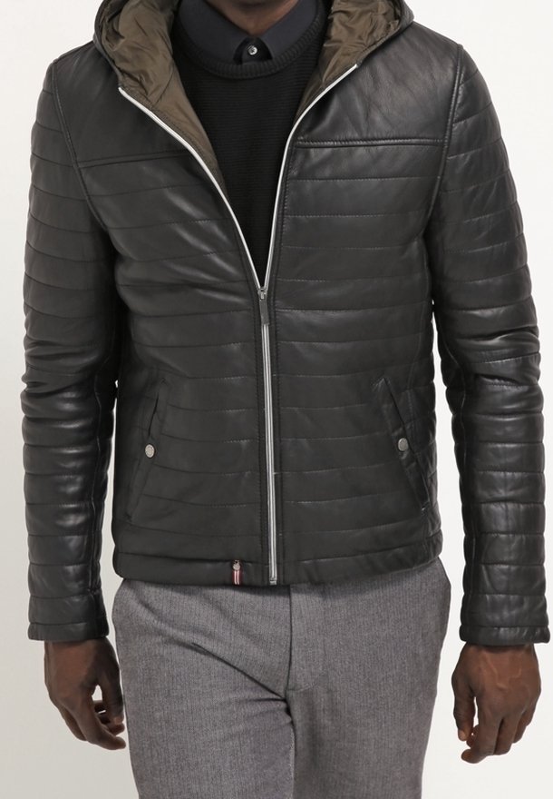 Giacca in pelle nera con design trapuntato, zip argentata e fodera della cappuccio verde oliva. Presenta tasche laterali e un discreto dettaglio del logo.