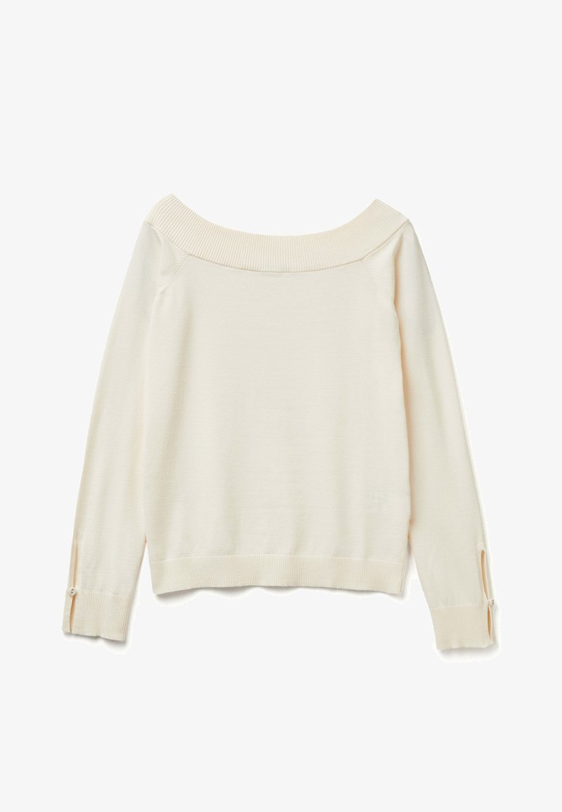 Slonovinový svetr s exponovaným ramenem, dlouhými rukávy s knoflíkovými rozparky a žebrovanými detaily kolem límce a manžet.