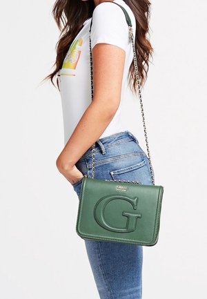 La borsa a tracolla in pelle verde presenta un logo "G" in rilievo, una tracolla a catena e un design strutturato. Tracolla regolabile e superficie liscia.