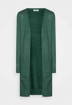 Garais, atvērtais kardigāns tumši zaļā adījumā. Tam ir ribotās piedurknes un gluda faktūra, kas ir piemērota slāņošanai. Nav aksesuāru vai rakstiem.