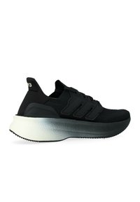Scarpe da ginnastica nere con tomaia in maglia, design a tre strisce nere e suola spessa con gradiente che passa dal bianco al nero.