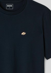 T-shirt en coton bleu marine avec un petit logo brodé de dinde beige sur la poitrine et une étiquette BZB taille L à l'intérieur du col.