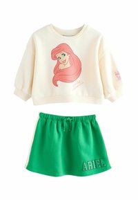 Sweatshirt crème avec un design de personnage aux cheveux roses, associé à une jupe verte avec une taille élastique et le texte "ARIEL".