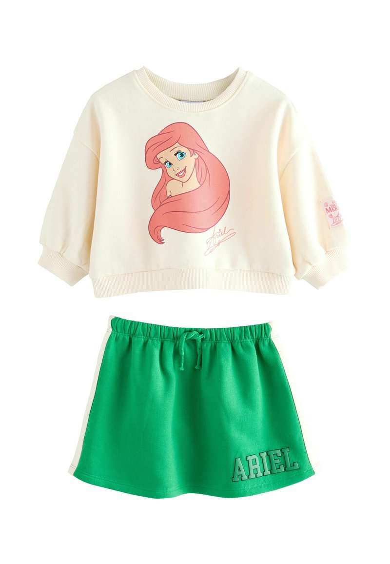 Sweatshirt crème avec un design de personnage aux cheveux roses, associé à une jupe verte avec une taille élastique et le texte "ARIEL".