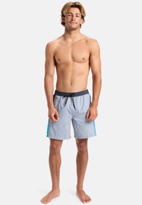 Šedé plavky vyrobené z ľahkého materiálu s textúrovaným povrchom, s čiernym elastickým pásom a modrými bočnými akcentmi.