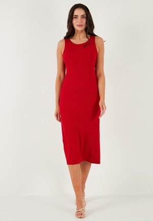 Red ribbed midi dress with a scoop neckline, fitted silhouette, and side slits for movement; smooth texture with a slight sheen.