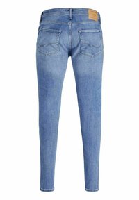 Light blue skinny jeans with a smooth denim texture. Features two back pockets with curved stitching and a brown leather patch at the waist.