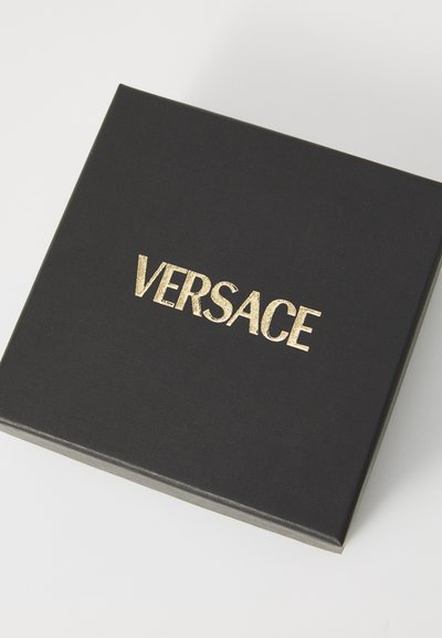 Fekete textúrájú doboz, arany "VERSACE" logóval a tetején. A doboz négyzet alakú és sima felületű.