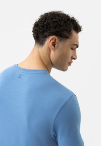 Hellblaue Bio-Baumwoll-T-Shirt mit Rundhalsausschnitt und kurzen Ärmeln, ausgestattet mit einem kleinen Drucketikett im Nackenbereich.