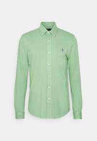 Světle zelená košile s dlouhým rukávem a knoflíkovým límcem, s malým tmavě modrým vyšitým logem koně na levé hrudi.