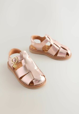Metalliska sandaler i roséguld med flätade remmar, öppen häl och spännedetalj. Texturerad fotbädd med blommönster. Gummisula.