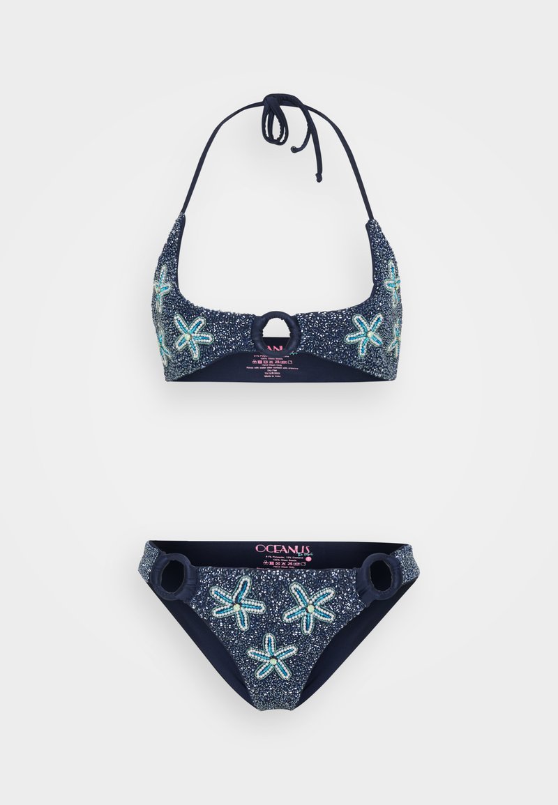 Marinblå bikini-set i strukturerad tyg, med sjöstjärnemönster i ljusblå detaljer, halterneck-topp med cirkulärt spänne och matchande underdelar.