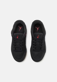 Črne semiš superge z rdečimi poudarki in črnimi vezalkami. Imajo gumijast podplat ter Jumpman logo na vložku in jeziku.