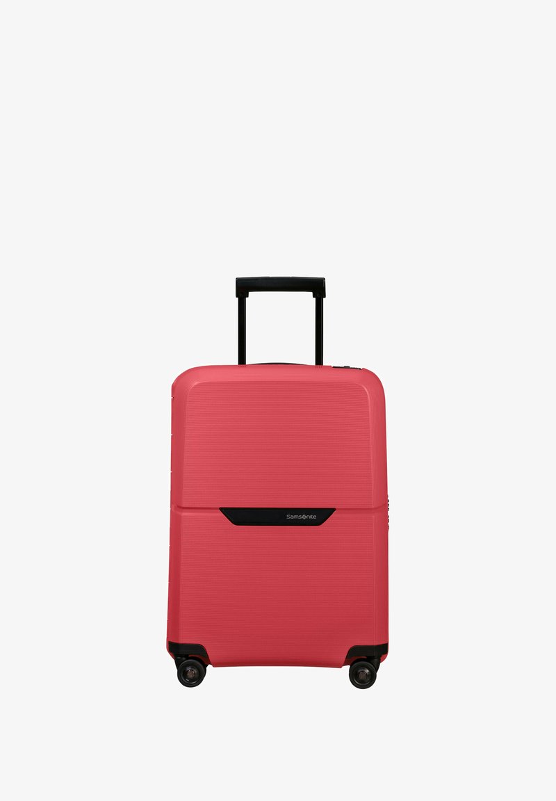Hard-shell suitcase in coral with textured grooves. Features a black telescopic handle and four wheels for mobility. Brand logo displayed.