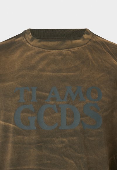 Olive zöld pamut póló, amely környakú, és a hátán merész, sötétkék színű "TI AMO GCDS" felirat látható.