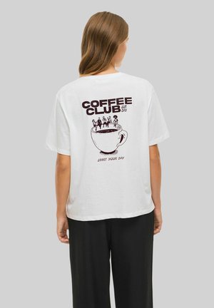 Vit bomull T-shirt med en svart tryckt design av en kaffekopp med figurer ovanpå, texten: "KAFFEKLUBB SÖNDAG" och "BÖRJA DIN DAG."