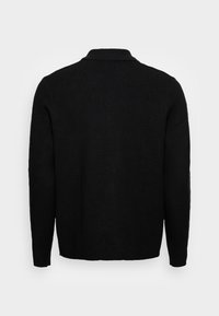 Pull noir à manches longues vu de dos avec un col simple et un ourlet droit, sur un fond clair uni.