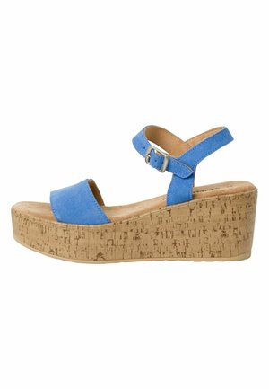 Sandale à plateforme en liège bleu en suède, avec une bride ajustable à la cheville et un design à bout ouvert. Texture lisse avec des détails de couture minimalistes.