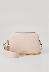 Beige leren crossbodytas met een ritssluiting, gouden ketting en stoffen band. Soepele textuur met een subtiel geperst logo aan de voorkant.