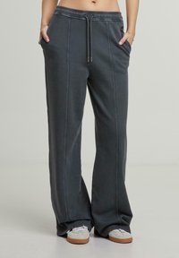 Donkergrijze joggingsbroek met een relaxed fit, voorzien van een koordje in de taille, twee zijzakken en contrasterende stikseldetails.