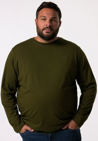 Olivově zelená košile s dlouhým rukávem vyrobená z bavlny, s kulatým výstřihem, volným střihem a malým embosovaným logem na hrudi.