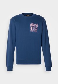 Granatowa bluza z długim rękawem, ściągaczami przy mankietach oraz okrągłym dekoltem. Z przodu znajduje się różowy nadruk z napisem „MIND'S EYE”.