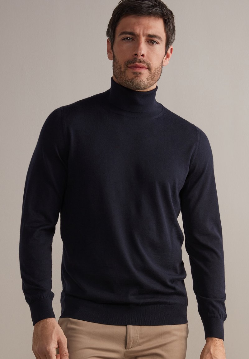 Maglione a collo alto blu navy con maniche lunghe, realizzato in un materiale morbido, presenta una silhouette aderente e polsini a coste per una vestibilità confortevole.