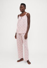 Ljusrosa mönstrad pyjamas med en ärmlös topp som har en nyckelhålskant och löst sittande byxor med matchande mönster.