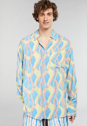Camicia a bottoni a motivi in verde chiaro, blu e rosa; presenta disegni fluidi e ondulati e una tasca sul petto; realizzata in un tessuto leggero.