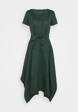 Zielona sukienka do kolan z krótkimi rękawami, okrągłym dekoltem i paskiem w talii. Posiada asymetryczny dół i miękką fakturę tkaniny.