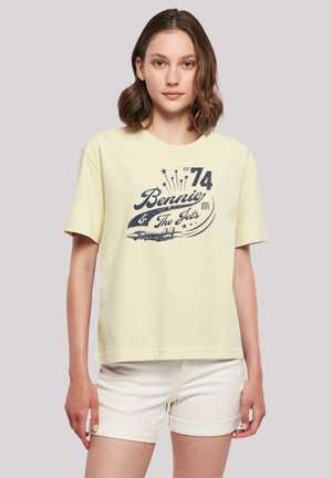 Gelbes Baumwoll-T-Shirt mit kurzen Ärmeln, rundem Ausschnitt und einem navyblauen Grafikdruck von "Bennie & The Jets", ergänzt mit Sternen und einem Flugzeugdesign.