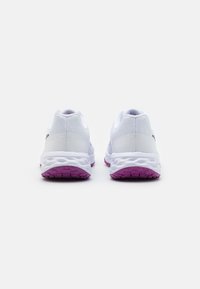 Scarpe sportive bianche con una tomaia testurizzata, colletto imbottito e suola viola a contrasto, che mostrano un design elegante e moderno.
