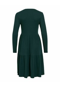 Robe à manches longues en tissu vert profond avec un corsage ajusté et une jupe évasée à volants. Design texturé à côtes. Encolure ronde simple.