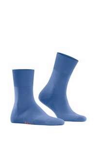 Niebieskie bawełniane skarpetki z prążkowanym ściągaczem, gładką teksturą, do długości połowy łydki, z małym pomarańczowym logo na podeszwie. Klasyczny design i kolor.