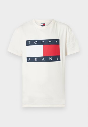 Roomkleurig katoenen T-shirt met een rechthoekige afbeelding waarop de woorden "TOMMY" en "JEANS" staan, op een navyblauwe achtergrond met een rode en witte blok.