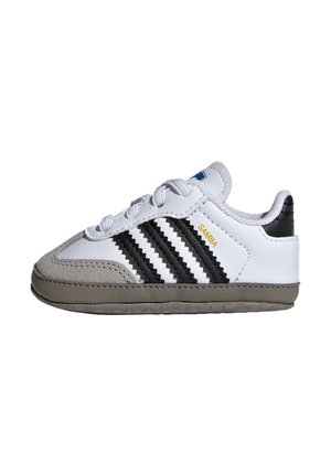 Hvid og grå Adidas Samba sneaker med sorte tre striber, gylden "SAMBA" tekst og grå sål, set fra siden.