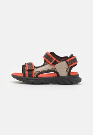 Sandalias impermeables marrones y negras con acentos rojos, correas ajustables, diseño de malla, suela acolchada y suela robusta.