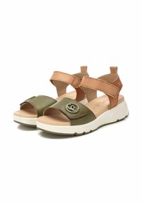 Sandalias verdes y beige con tiras texturizadas, un emblema en relieve en la parte frontal y una suela de goma blanca con un patrón de tracción.