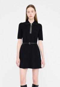 Abito nero a maniche corte con colletto con zip e una cintura aderente in vita. Tessuto liscio e taglio dritto.