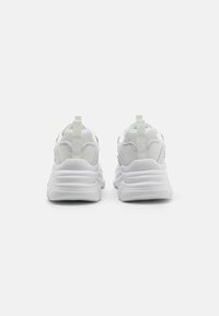 White running shoes featuring a smooth material, rounded silhouette, cushioned sole, and minimalist design with a pull tab at the heel.