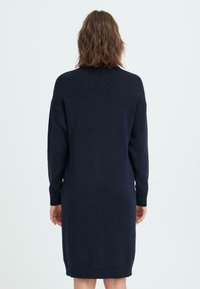 Námořnické pletené šaty s kulatým výstřihem, dlouhými rukávy a žebrovanými manžetami, ve tvaru A, sahající do poloviny stehna.