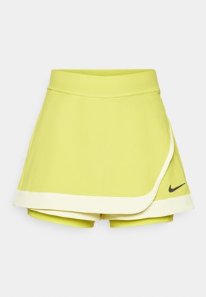 Limegrønn tennis skjørt med tilkoblede shortser; har et lagdelt design, svart Nike-logo og hvit kanting på kanten.