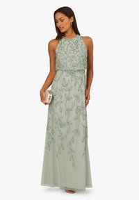 Sukienka na szyję, długa, z miękkiego mięty zielonego szyfonu z kwiatowym zdobieniem z koralików. Płynna sylwetka i subtelny połysk. W zestawie z małą kopertówką.